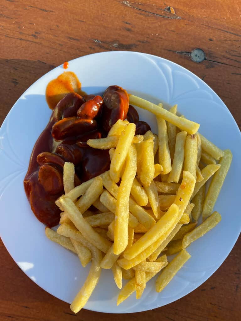 Teller mit Currywurst mit Pommes