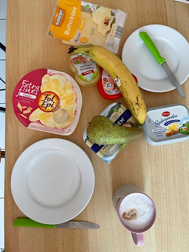 Frühstückstisch mit Teller Besteck Käse und Obst