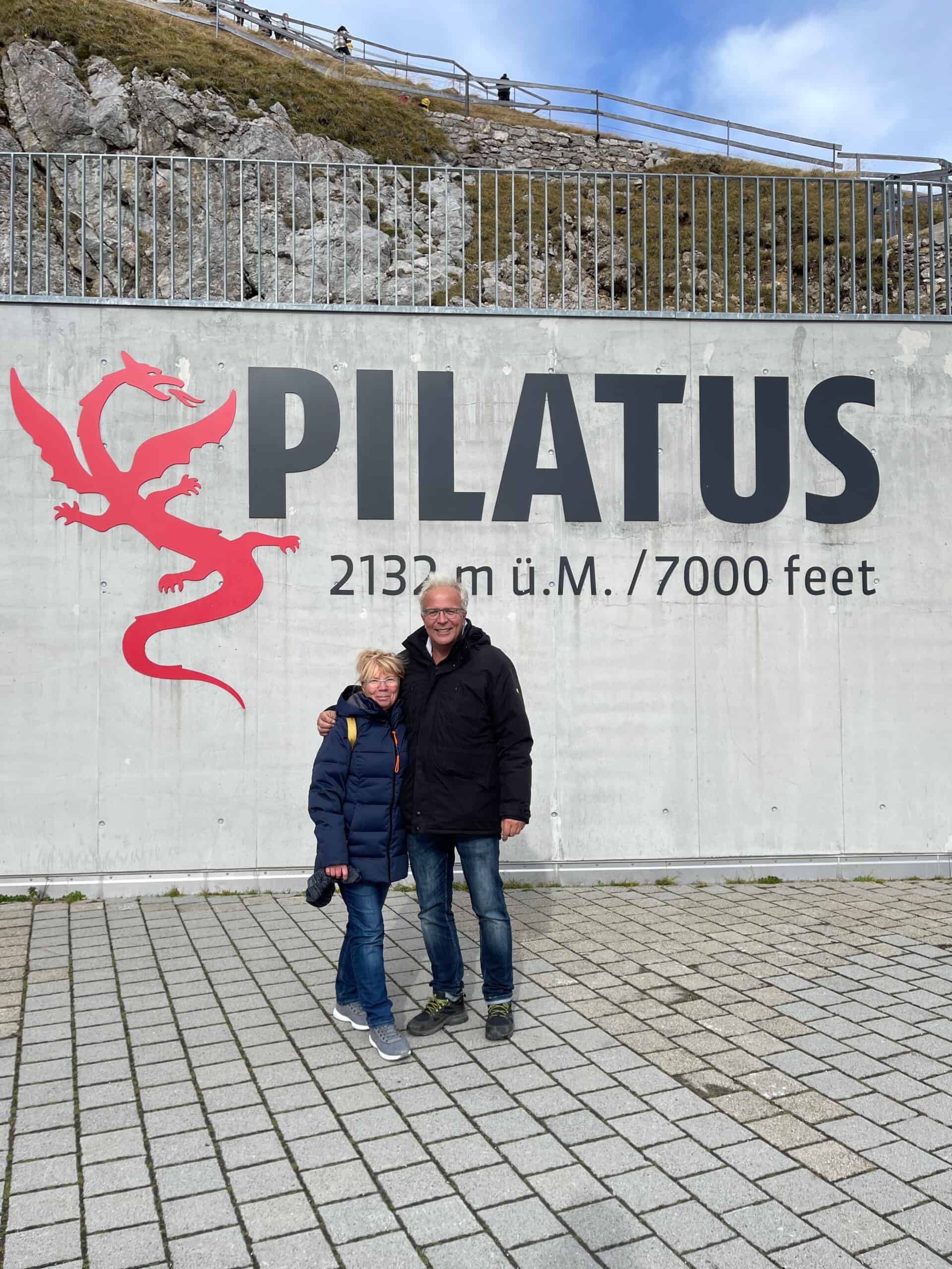 IMG_2023-10-31-184334 Zwei Menschen vor dem Schild mit der Aufschrift Pilatus